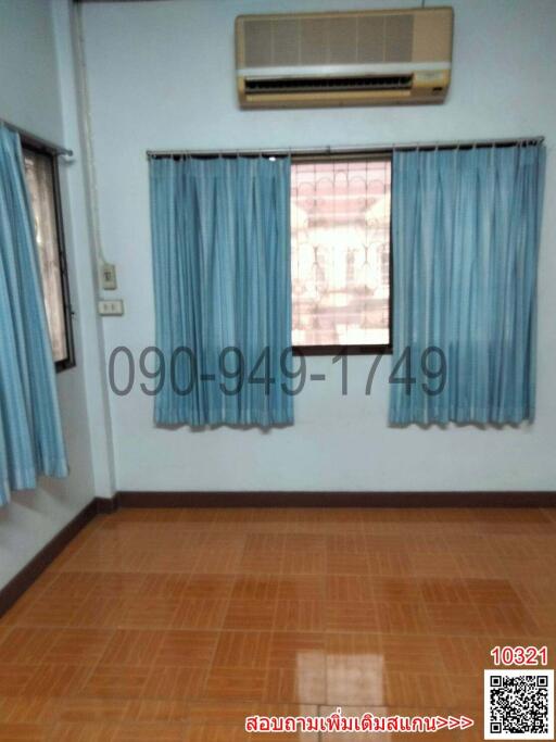 Empty room with tiled flooring, window with blue curtains, and air conditioning unit