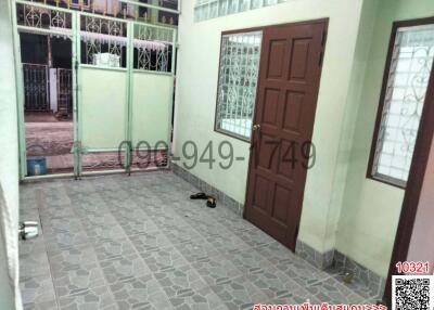 Tiled residential entryway with brown door and security gate
