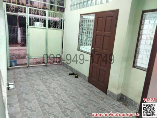 Tiled residential entryway with brown door and security gate