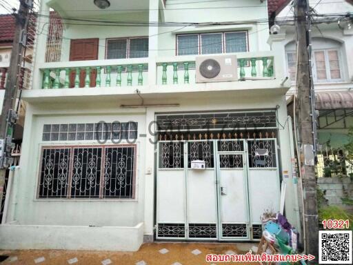 Front view of a two-storey residential building with a gated entrance