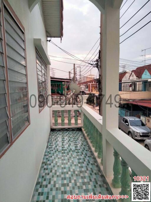 Residential house balcony with green railing overlooking the street