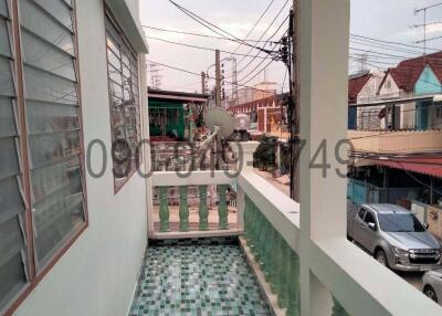Residential house balcony with green railing overlooking the street