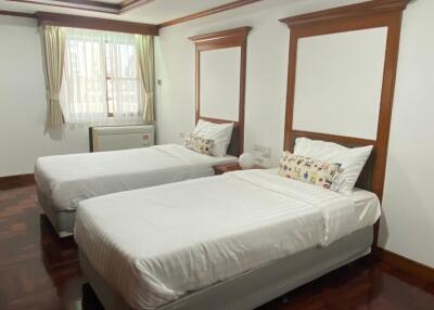 Spacious bedroom with twin beds and hardwood floor