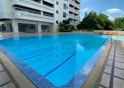 Swimming pool with clear blue water adjacent to a modern residential building