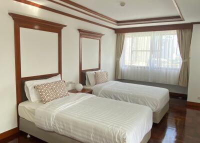 Spacious bedroom with two single beds and elegant wood trim