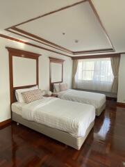 Spacious bedroom with two single beds and elegant wood trim