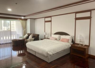 Spacious bedroom with polished hardwood floors and ample natural light