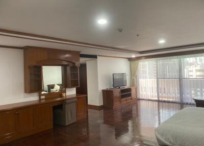 Spacious bedroom with wooden furniture and ample natural light