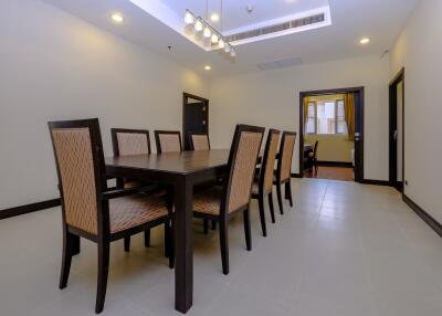 Spacious dining room with large table and rattan chairs