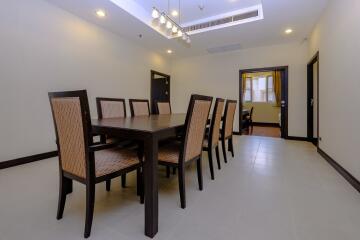 Spacious dining room with large table and rattan chairs