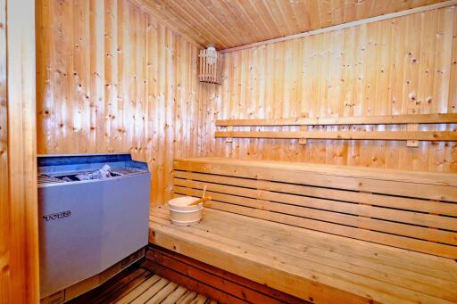 Cozy wooden sauna room with benches and heater