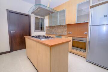 Modern kitchen with wooden cabinets, stainless steel appliances, and tile backsplash