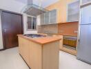 Modern kitchen with wooden cabinets, stainless steel appliances, and tile backsplash