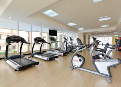 Modern gym facility with various exercise machines and large windows