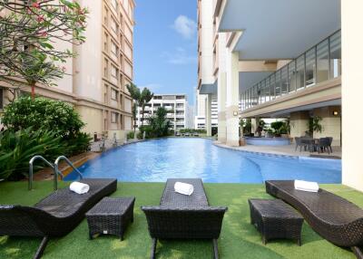Luxury condominium common area with swimming pool and loungers