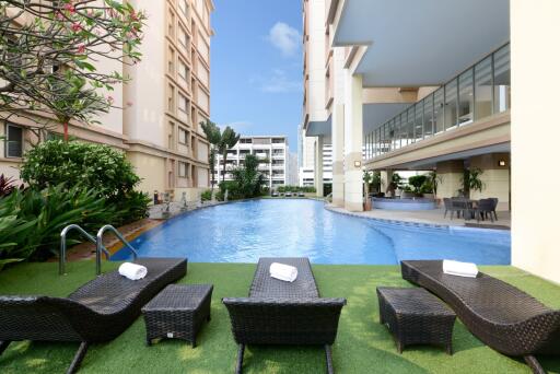 Luxury condominium common area with swimming pool and loungers