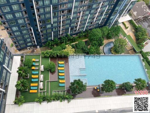 Aerial view of a modern residential building complex with swimming pool and garden