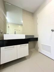 Modern bathroom with white tiles and black vanity cabinet