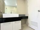 Modern bathroom with white tiles and black vanity cabinet