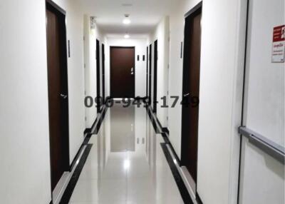 Long, well-lit hallway with multiple doors in a modern residential building
