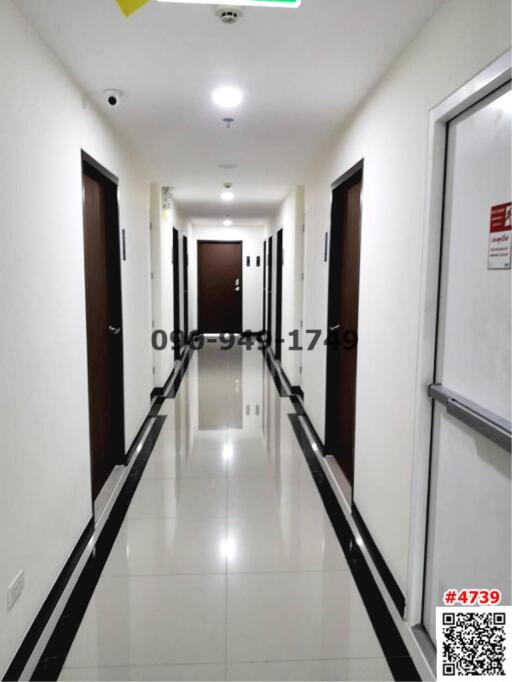 Long, well-lit hallway with multiple doors in a modern residential building