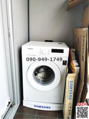 Compact laundry area with a new Samsung washing machine and storage space