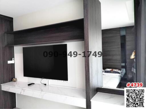 Modern bedroom interior with wall-mounted TV and built-in cabinets
