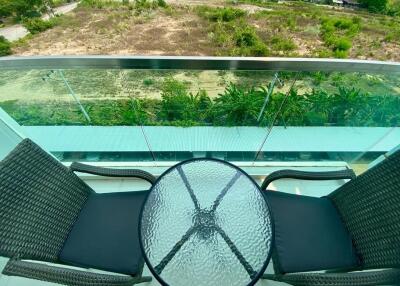 Modern balcony with glass balustrade overlooking green area