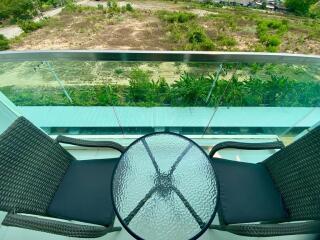 Modern balcony with glass balustrade overlooking green area