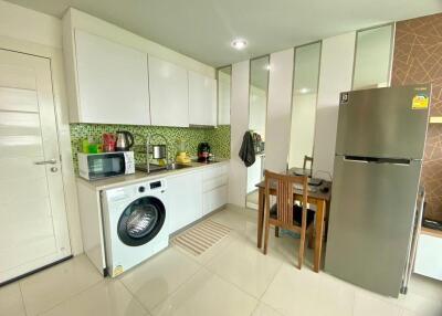 Modern kitchen with white cabinets, tile backsplash, and stainless steel appliances