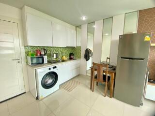 Modern kitchen with white cabinets, tile backsplash, and stainless steel appliances