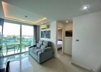 Modern living room with bedroom view, ample lighting, and balcony access