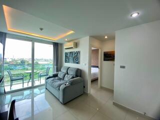 Modern living room with bedroom view, ample lighting, and balcony access