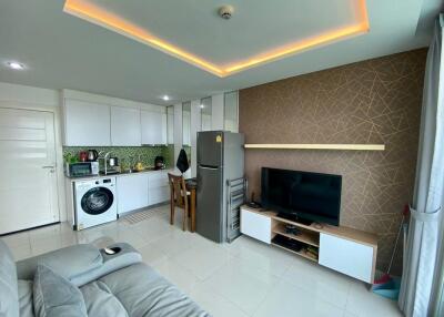 Modern open-plan living room with integrated kitchen, furnished with contemporary decor