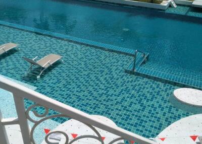 Swimming pool with lounging chairs and mosaic tiles