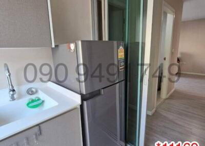 Compact modern kitchen with stainless steel refrigerator and balcony access