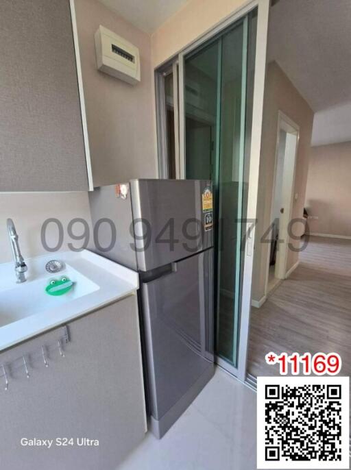 Compact modern kitchen with stainless steel refrigerator and balcony access