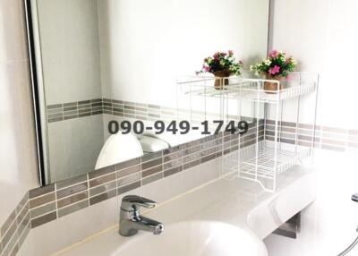 Modern white bathroom with a sleek design, featuring a basin, faucet, and subtle tile accents.