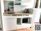 Compact modern kitchenette with appliances and shelving