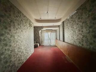 Spacious hallway with red carpet and floral wallpaper