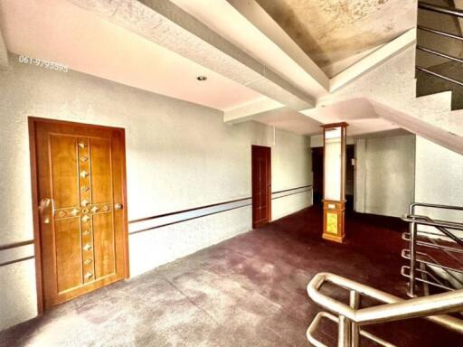 Spacious entryway with wooden front door and staircase