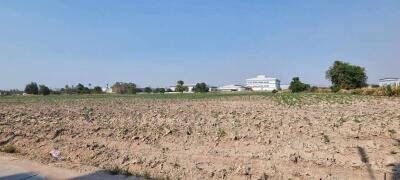 Empty plot of land available for development with buildings in the background