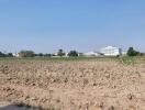 Empty plot of land available for development with buildings in the background