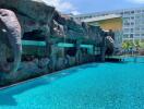 Luxurious outdoor swimming pool with artificial rock formations and adjacent building