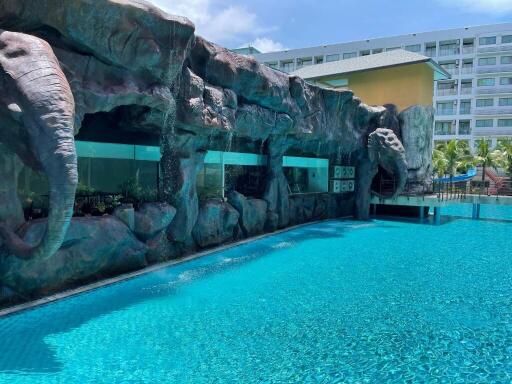 Luxurious outdoor swimming pool with artificial rock formations and adjacent building