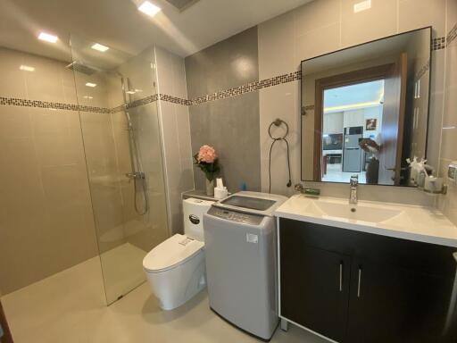 Modern bathroom with shower stall, washing machine, and vanity