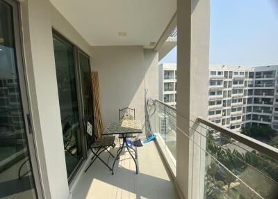 Spacious balcony with outdoor seating and a view of surrounding apartments