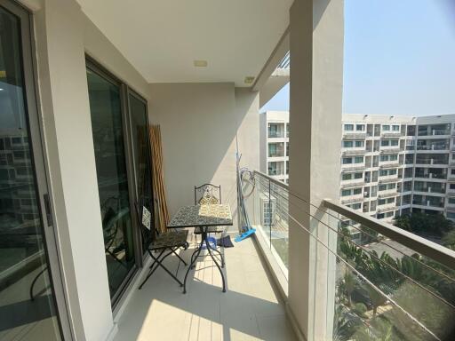 Spacious balcony with outdoor seating and a view of surrounding apartments