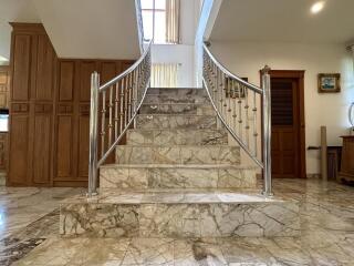 Elegant entrance hall with marble staircase and wooden doors
