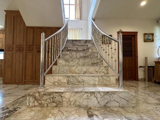 Elegant entrance hall with marble staircase and wooden doors